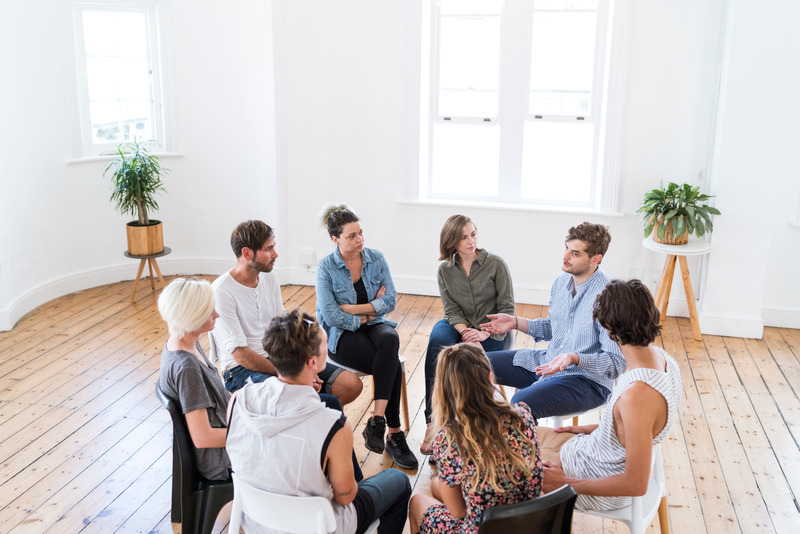groupe d'individu assis sur une chaise en rond